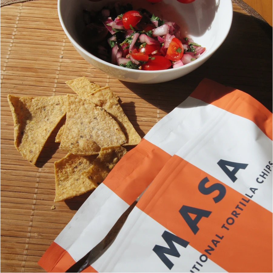 MASA Original tortilla chips with salsa on a woven mat